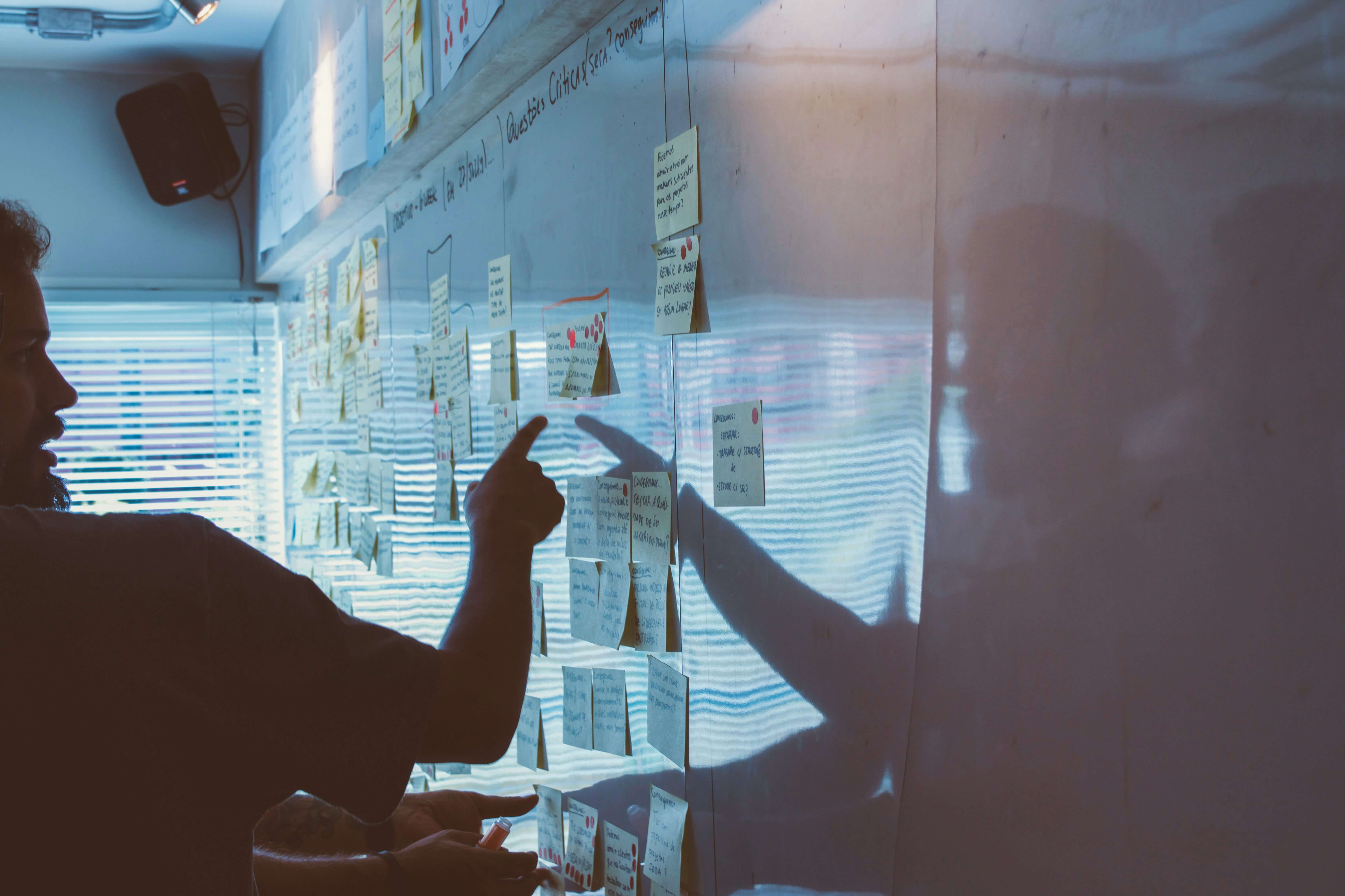 Man pointing sticky notes white board