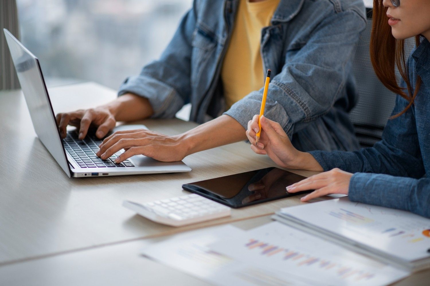 Close-up of office collaboration with a laptop and tablet