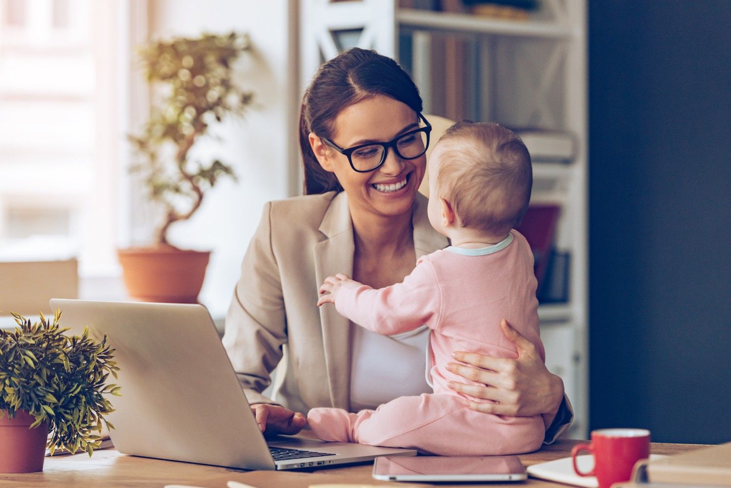 Working mother with baby laptop home office