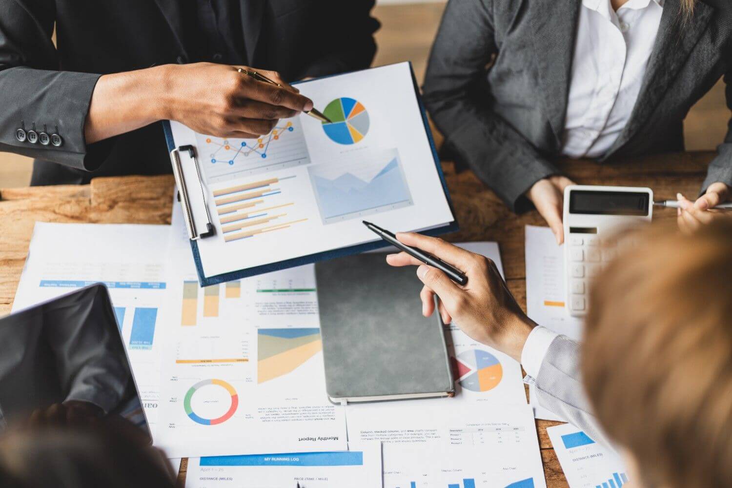 Business partners analyzing financial charts and data graphs during office meeting