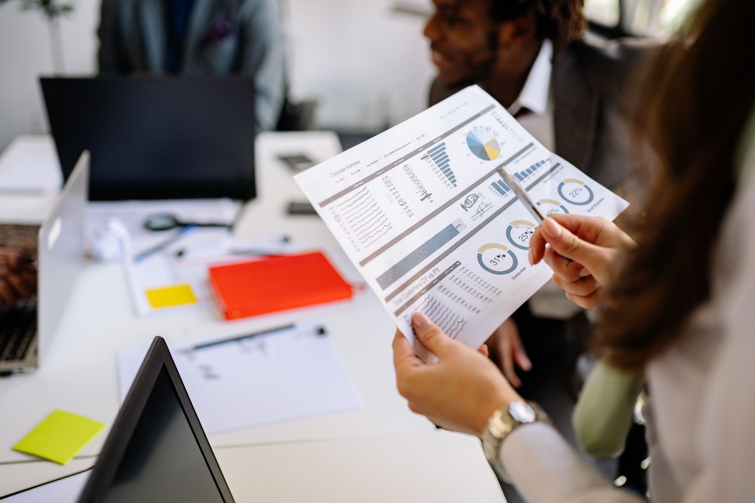 Financial analysts pointing at report charts